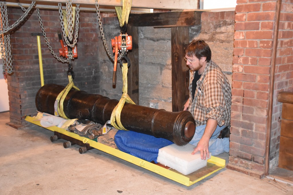 Our Chief Curator, Jason, helps protect the cannon as its lowered onto a wheeled cart for moving.