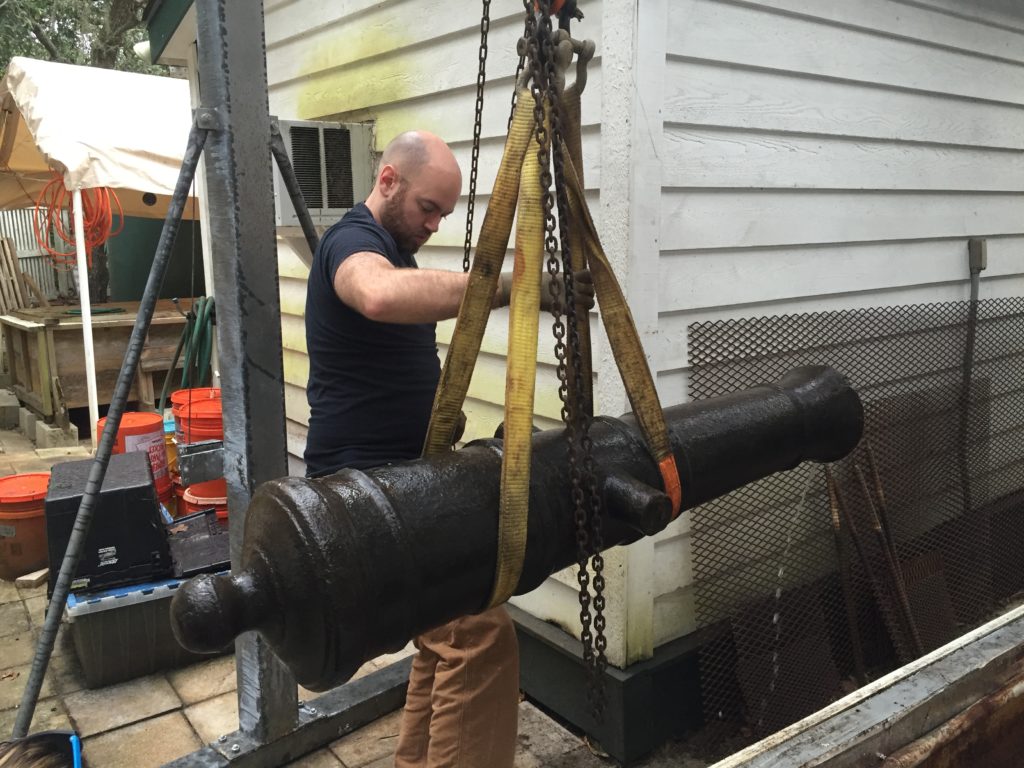 Assistant Archaeological Conservator, Andrew, helps lift the Wrecked! cannon from the hot bath.