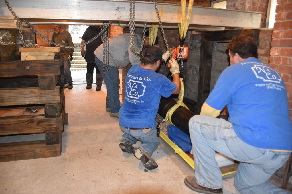 Nieman & Co. movers lifting the first cannon out of the basement.